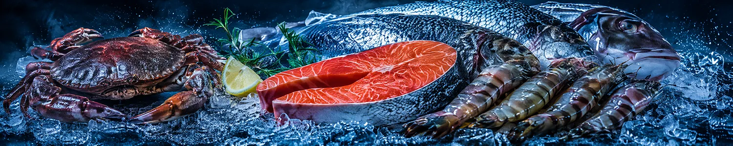 Ryby, krewetki i krab na lodzie w chłodniczej ekspozycji produktów mrożonych IGLOMEN